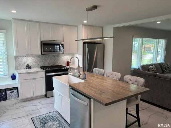 a kitchen with granite countertop a sink appliances and cabinets