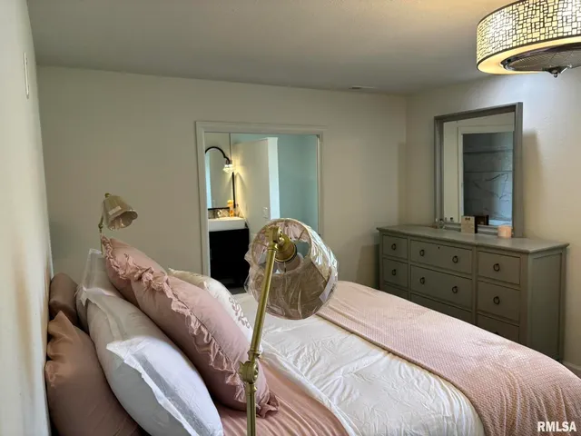 a bedroom with a bed and a mirror on dresser