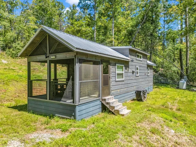 a view of wooden house with a yard