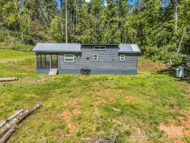 a house view with a big yard plants and large trees