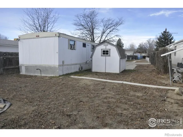 a view of a white house with a big yard and large tree