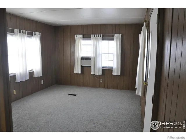 a view of an empty room with a fireplace and a window