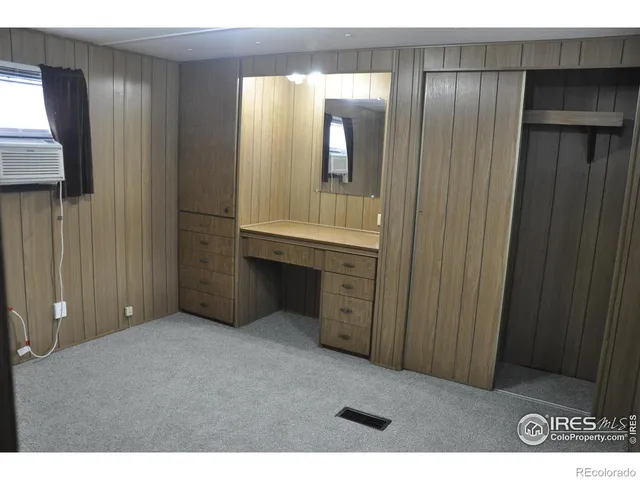 a view of an empty room with window and bathroom