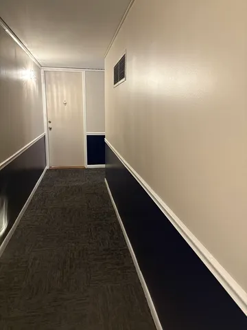 a view of hallway with wooden floor