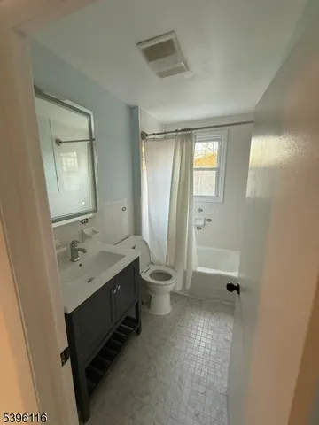a bathroom with a granite countertop sink toilet a mirror and shower