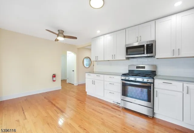 a kitchen with stainless steel appliances granite countertop a stove microwave and sink