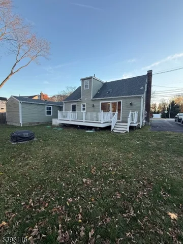 a front view of a house with a yard and large trees