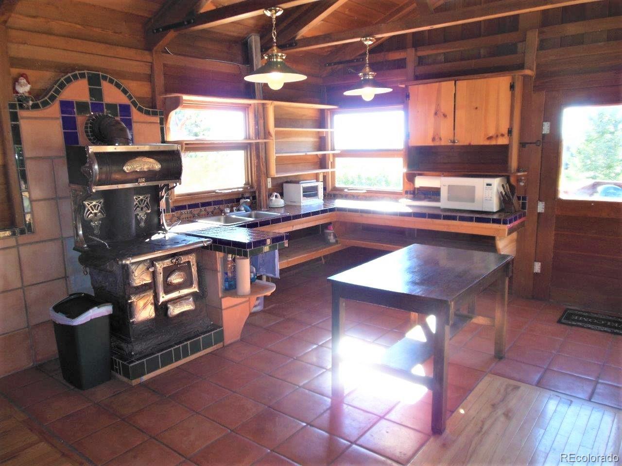 481 San Miguel Road Westcliffe, CO 81252 - Photo 11 of 26 a kitchen with stainless steel appliances granite countertop a stove a sink and a microwave