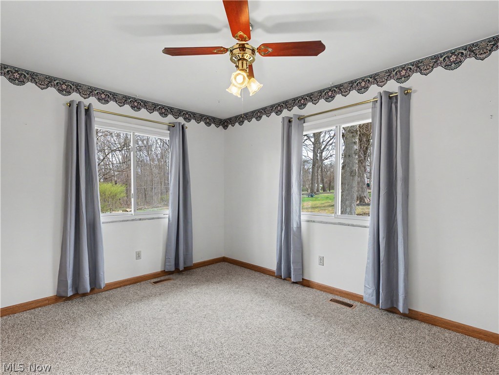 8406 Whipporwill Road Ravenna, OH 44266 - Photo 22 of 26 Bedroom with carpeting, two windows to scenic views, ceiling fan and closet