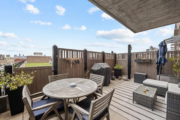 a roof deck with a table and chairs