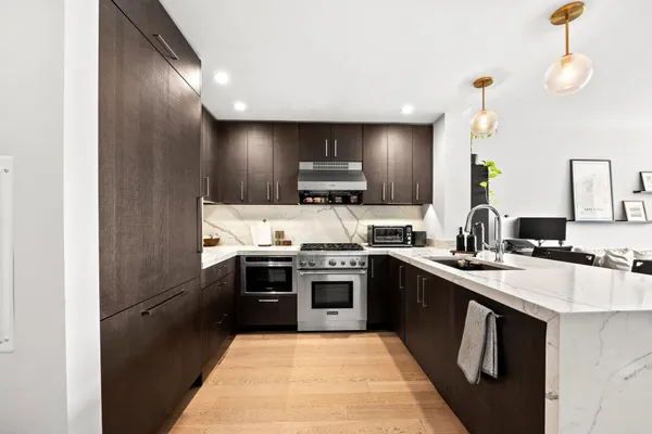 a kitchen with stainless steel appliances granite countertop a stove a sink and a refrigerator
