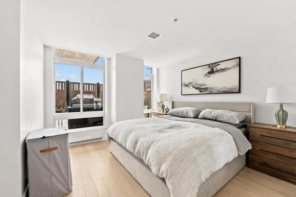 a spacious bedroom with a bed and glass wall painting