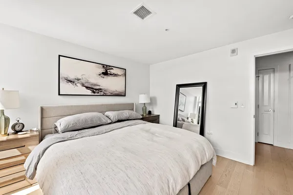 a bedroom with a bed and a painting on the wall