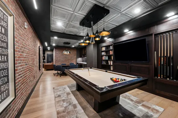 a room with pool table flat screen tv and windows