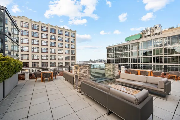 a roof deck with couch and potted plants