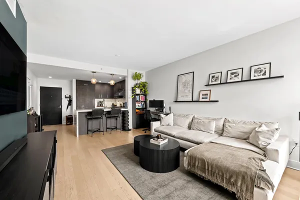 a living room with furniture and view of kitchen