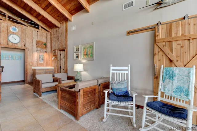 a living room with furniture a couch and paintings on the wall