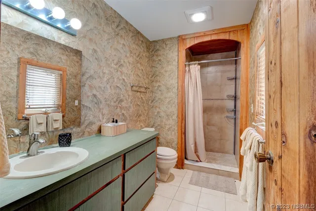 a bathroom with a double vanity sink mirror and shower