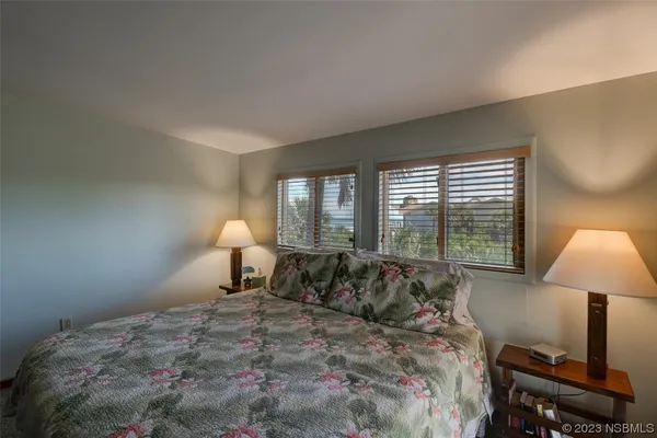 a bedroom with a bed and a lamp next to a window