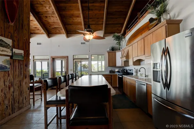 a kitchen with stainless steel appliances granite countertop table chairs and a refrigerator