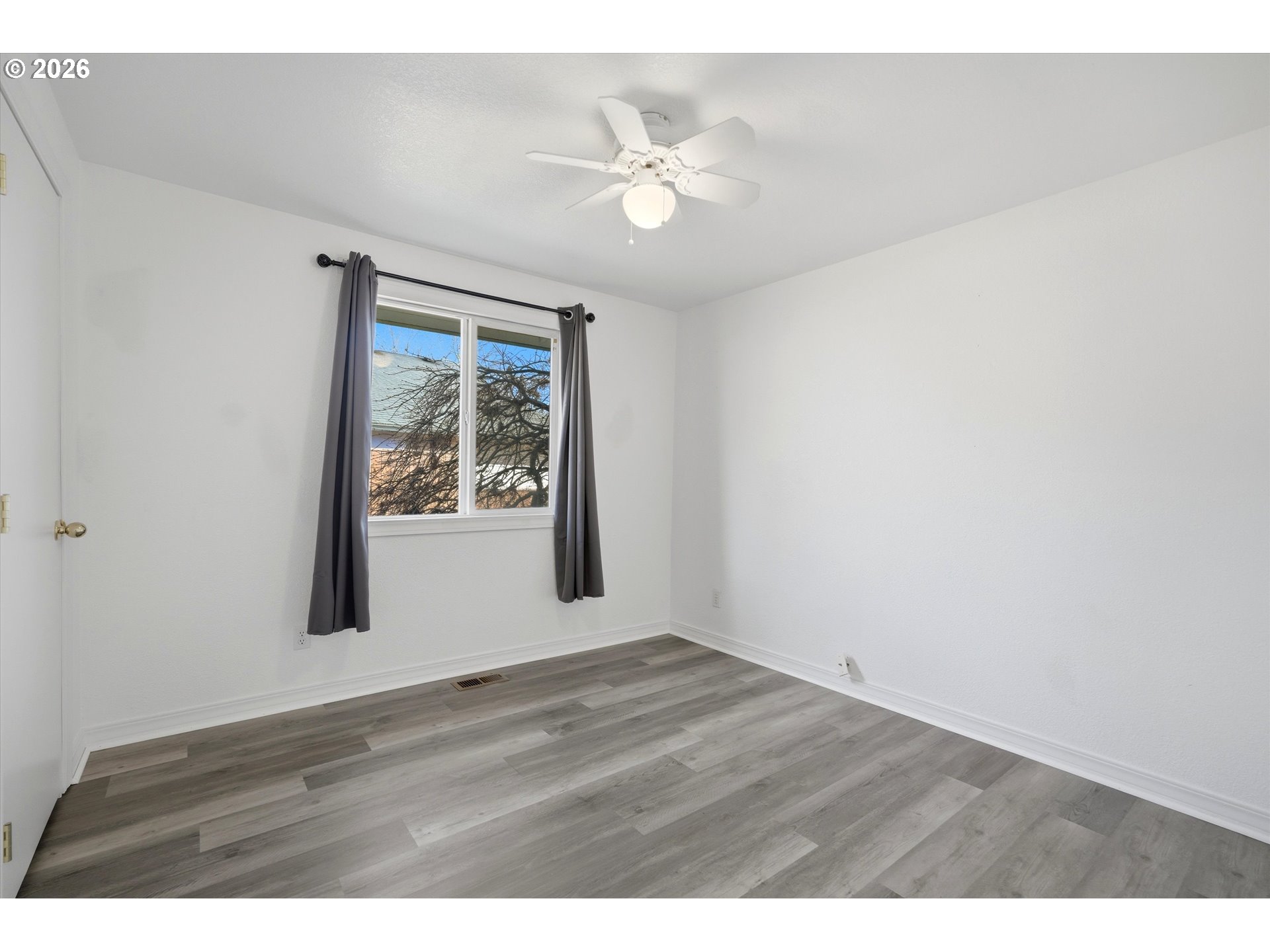 1255 Southwest 217th Avenue Beaverton, OR 97003 - Photo 17 of 33 a view of an empty room with wooden floor and a window