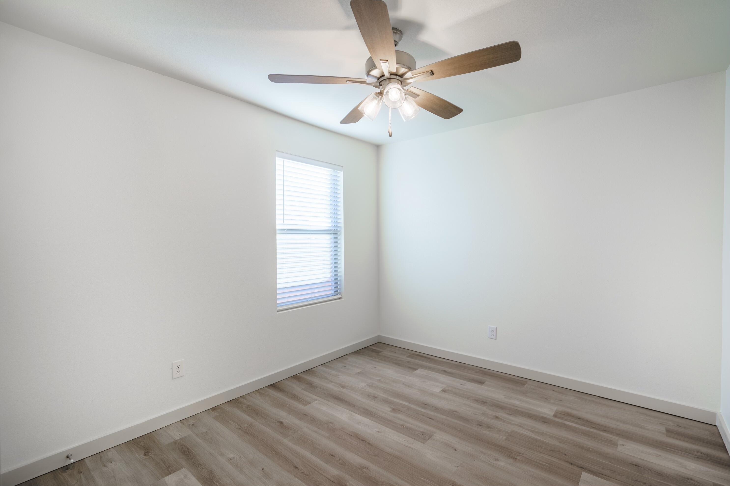 7709 Date Avenue Lubbock, TX 79404 - Photo 2 of 9 an empty room with a window and a fan