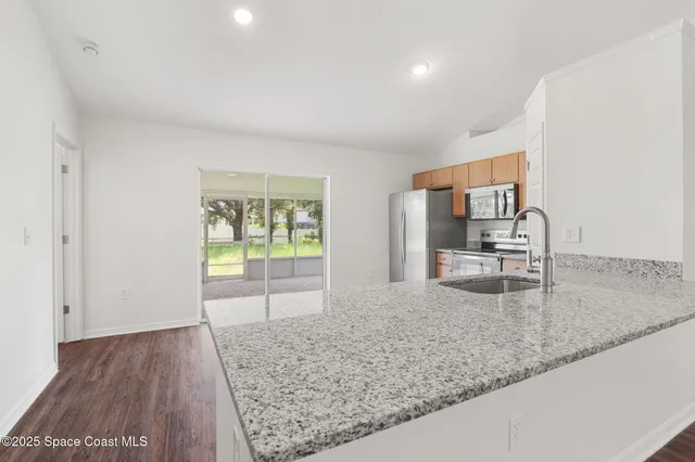 a view of a kitchen with a sink and cabinets