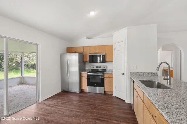 a kitchen with stainless steel appliances granite countertop a refrigerator and a sink