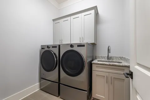 a utility room with sink dryer and washer