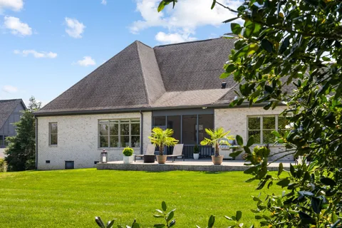 a view of a house with swimming pool and sitting area