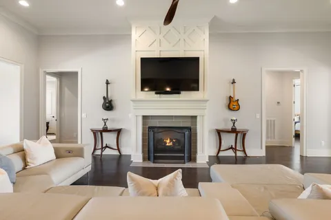 a living room with furniture a flat screen tv and a fireplace