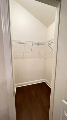 an empty room with wooden floor chandelier fan and windows