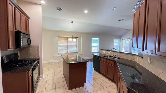 a kitchen with stainless steel appliances granite countertop a sink and a stove