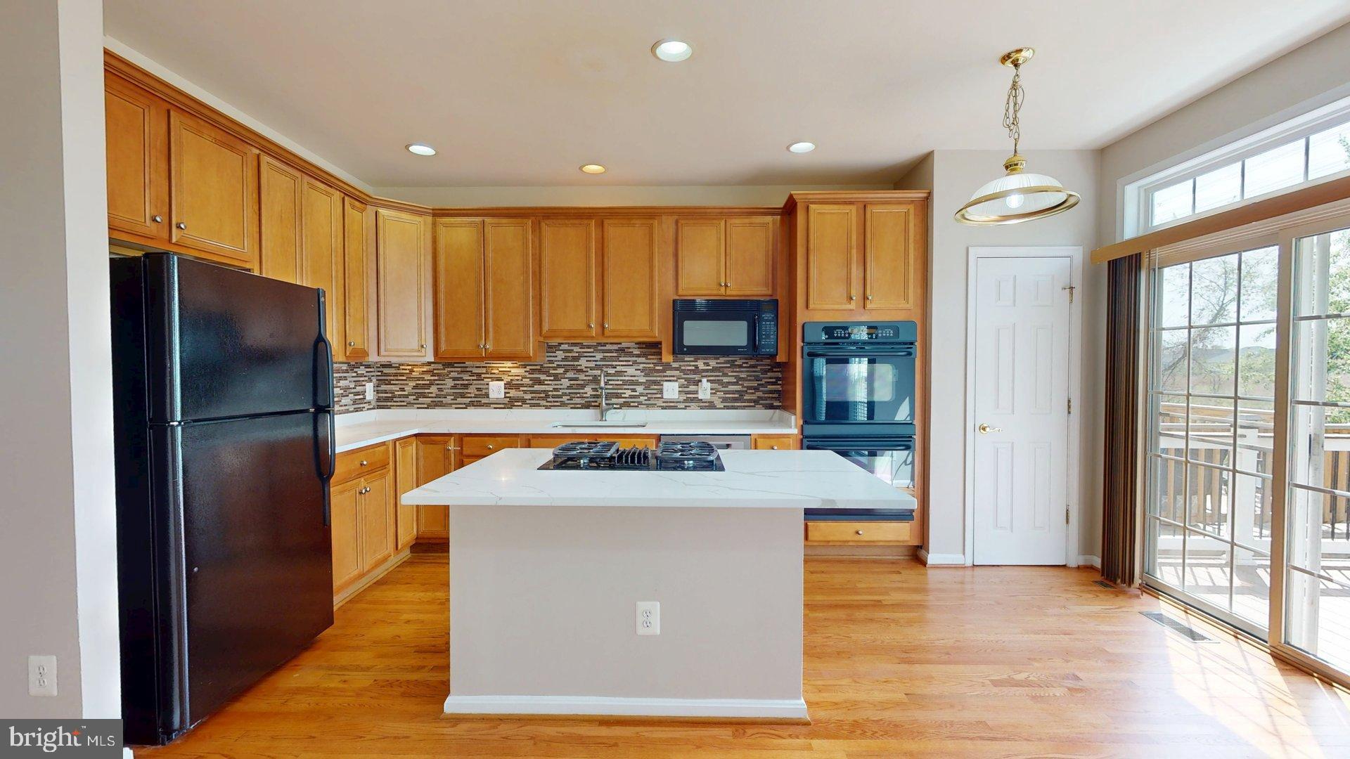 41867 Cinnabar Square Aldie, VA 20105 - Photo 11 of 26 a kitchen with stainless steel appliances granite countertop a refrigerator a stove and a wooden floors