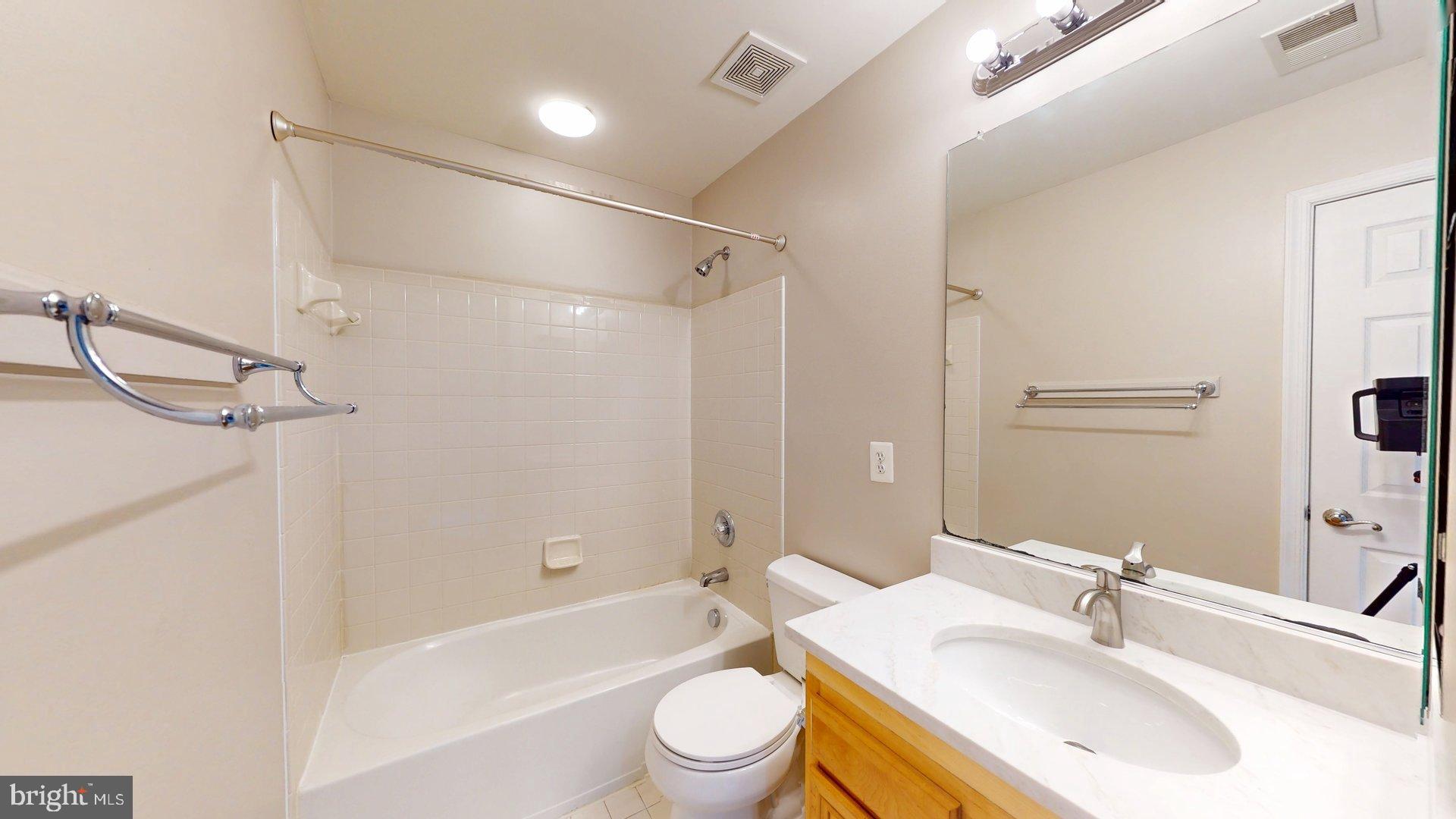41867 Cinnabar Square Aldie, VA 20105 - Photo 17 of 26 a bathroom with a bathtub shower sink vanity mirror and toilet