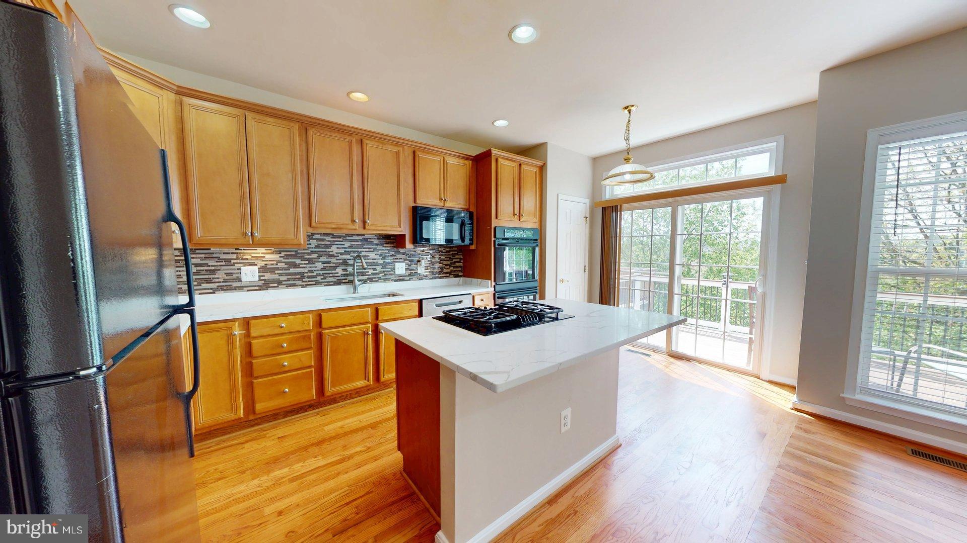 41867 Cinnabar Square Aldie, VA 20105 - Photo 7 of 26 a kitchen with stainless steel appliances granite countertop a sink stove and refrigerator