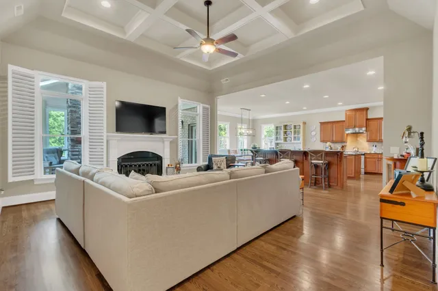 a bedroom with a bed a chair and potted plant on the dresser