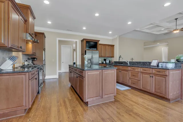 a kitchen with stainless steel appliances kitchen island granite countertop a table and chairs in it