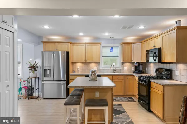 a kitchen with granite countertop a refrigerator stove microwave and sink