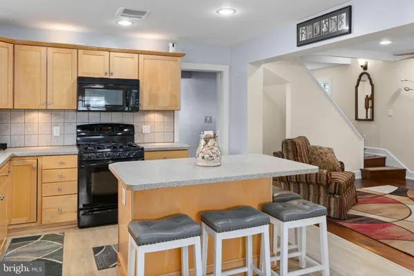 a kitchen with a table chairs microwave and cabinets