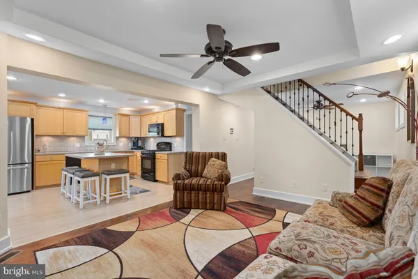 a living room with furniture kitchen view and a chandelier