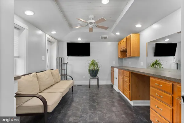 a living room with furniture a flat screen tv and a view of kitchen