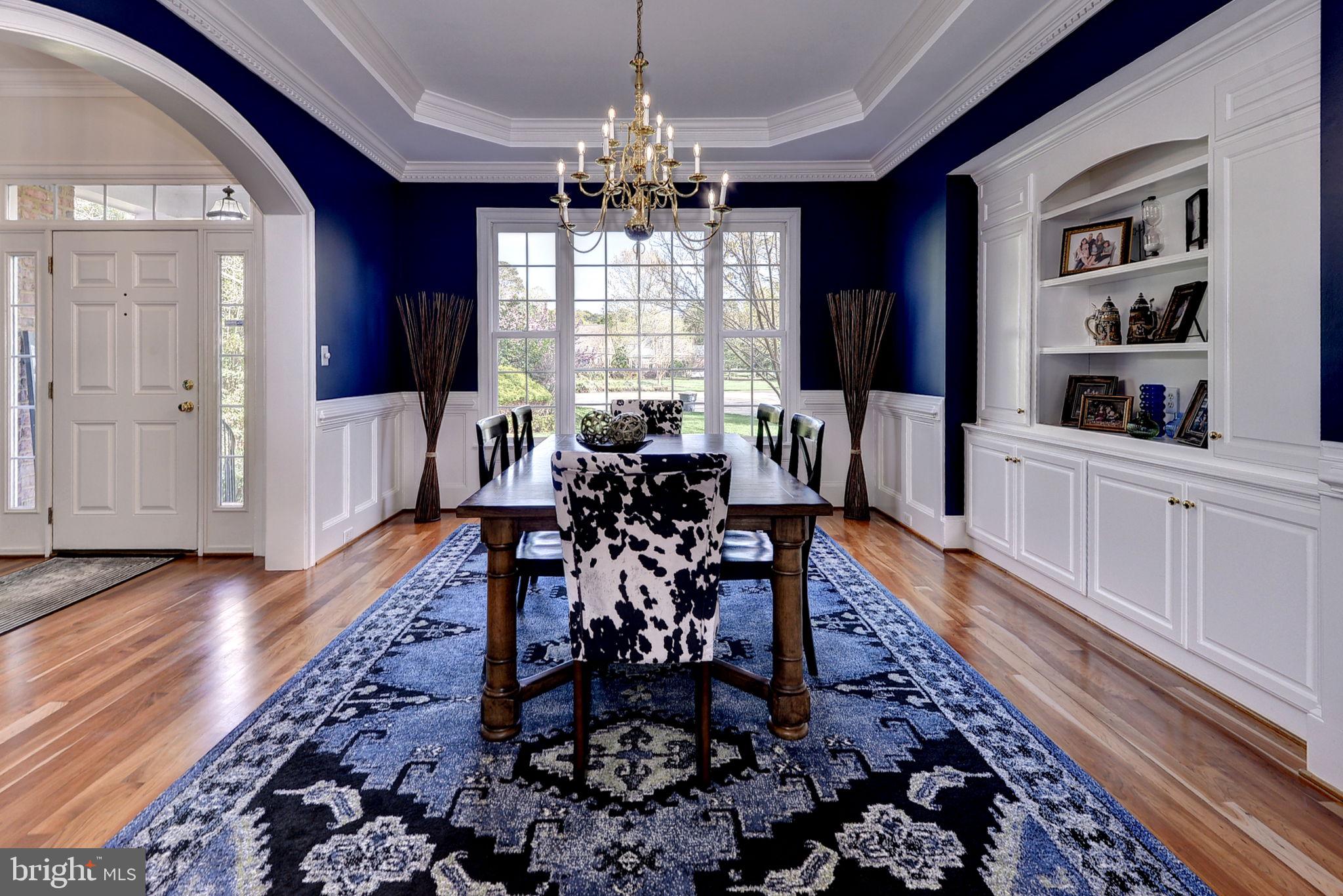 2076 Harpers Mill Road Williamsburg, VA 23185 - Photo 12 of 63 a dining room with wooden floor a chandelier a wooden table and chairs
