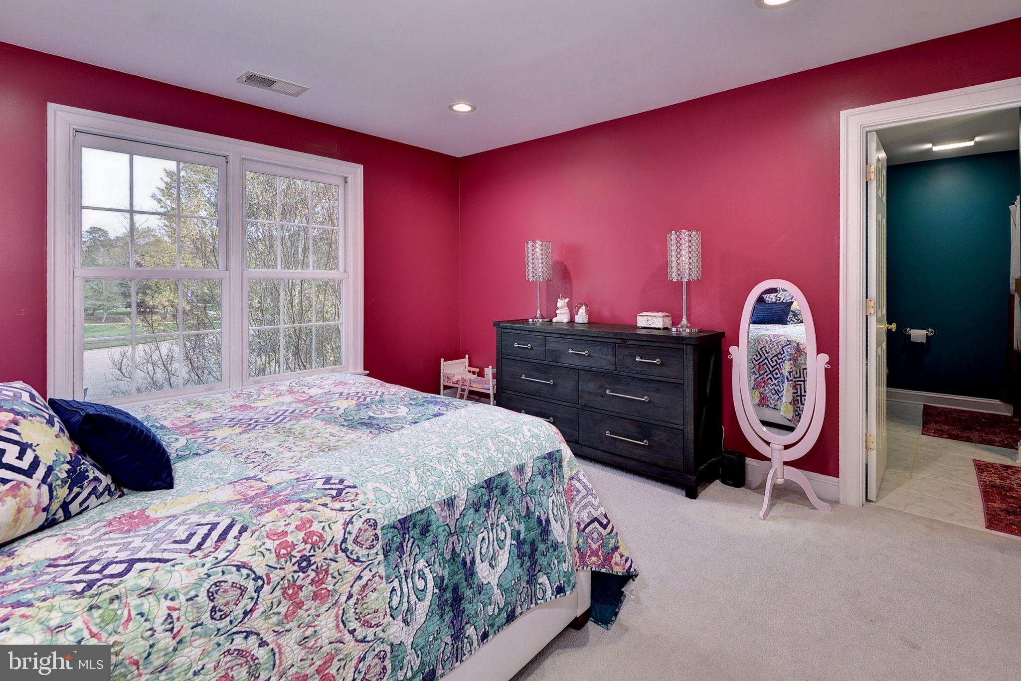 2076 Harpers Mill Road Williamsburg, VA 23185 - Photo 39 of 63 a spacious bedroom with a bed and a dresser next to a window