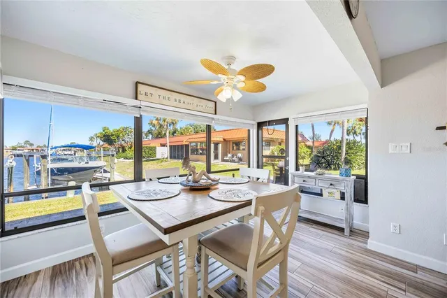 a dining room with stainless steel appliances furniture a large window and a chandelier