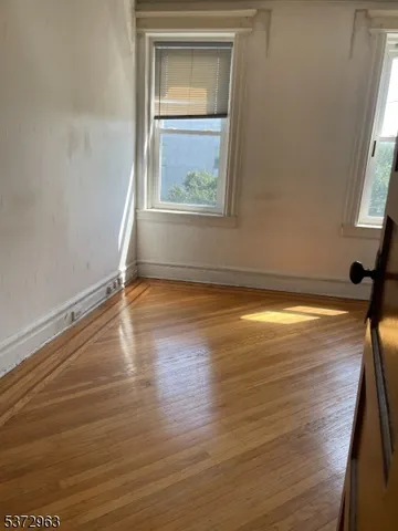 a view of a room with wooden floor and a window