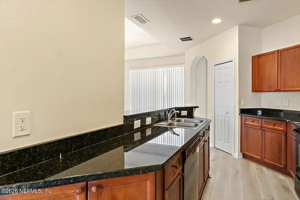 a kitchen with granite countertop a sink a stove and cabinets