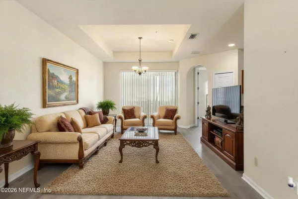 a living room with furniture and a chandelier
