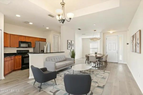a living room with furniture a dining table and kitchen view