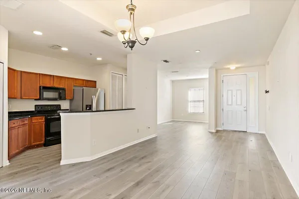a view of kitchen with stainless steel appliances refrigerator stove microwave and cabinets
